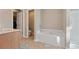 Well-lit bathroom featuring a soaking tub, shower, and access to closet and toilet at 145 Sunset Ln, Woodstock, GA 30189