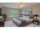 This staged bedroom features a large window, a ceiling fan and well placed furniture at 145 Sunset Ln, Woodstock, GA 30189