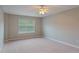 Spacious carpeted bedroom features neutral walls, large window, and a modern ceiling fan at 145 Sunset Ln, Woodstock, GA 30189