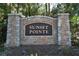 Community sign with stone pillars and inscription displaying the community name at 145 Sunset Ln, Woodstock, GA 30189