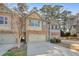 Charming townhome featuring a stone facade, a two-car garage, and beautiful landscaping at 145 Sunset Ln, Woodstock, GA 30189