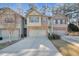 Exterior elevation of the townhome with an attached garage and stone and siding at 145 Sunset Ln, Woodstock, GA 30189