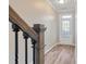 Hallway with hardwood flooring, decorative railing and view of glass paneled door at 145 Sunset Ln, Woodstock, GA 30189