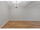 Large and empty living room, showing neutral paint and a modern chandelier at 145 Sunset Ln, Woodstock, GA 30189
