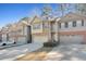 Charming multi-story townhomes with attached garages, varied exteriors, and well-maintained landscaping at 145 Sunset Ln, Woodstock, GA 30189