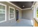 Inviting front porch with a welcoming entrance door, welcome mat, and freshly painted gray brick and trim at 299 Fletcher Street Sw, Atlanta, GA 30315