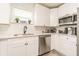 Bright kitchen features white cabinets, stainless steel appliances, gray backsplash and quartz countertops at 299 Fletcher Street Sw, Atlanta, GA 30315