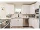 Bright kitchen features white cabinets, stainless steel appliances, gray backsplash and quartz countertops at 299 Fletcher Street Sw, Atlanta, GA 30315