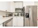 Bright kitchen features white cabinets, stainless steel appliances, gray backsplash and quartz countertops at 299 Fletcher Street Sw, Atlanta, GA 30315