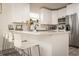 Bright kitchen features white cabinets, stainless steel appliances, gray backsplash and quartz countertops and breakfast bar at 299 Fletcher Street Sw, Atlanta, GA 30315