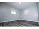 A bright bedroom featuring luxury vinyl flooring and two windows at 5042 Central Church Rd, Douglasville, GA 30135