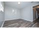 A bright bedroom featuring luxury vinyl flooring and a window at 5042 Central Church Rd, Douglasville, GA 30135