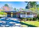 Single-story brick home with attached carport, covered porch, and a well manicured lawn at 5042 Central Church Rd, Douglasville, GA 30135