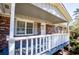 Detail of a front porch with a white railing, wood floor, and brick siding at 5042 Central Church Rd, Douglasville, GA 30135