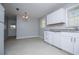 Spacious eat-in kitchen with white cabinets, granite countertops, and modern lighting at 5042 Central Church Rd, Douglasville, GA 30135