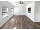 Bright living room with modern wood flooring and ceiling fan, and natural light from two windows at 6206 Redan Overlook, Lithonia, GA 30058