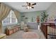 Bedroom features neutral walls, a crib, dresser, area rug, and window with natural light at 2113 N Landing Way, Marietta, GA 30066