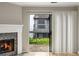 View of a balcony from inside, showcasing white curtains, a fireplace, and sliding glass door at 30 Finch Ne Trl, Atlanta, GA 30308