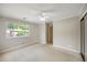 Bedroom featuring light walls, a ceiling fan, carpeted floors and large window at 30 Finch Ne Trl, Atlanta, GA 30308