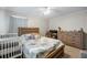 Bedroom featuring a ceiling fan, a comfortable bed, a crib, a desk area, and natural light through the window at 30 Finch Ne Trl, Atlanta, GA 30308