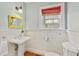 Charming bathroom featuring white beadboard, a pedestal sink, a window with an orange roman shade, and hardwood floors at 1446 High Point Ne Pl, Atlanta, GA 30306