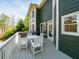Green home back porch with seating overlooking a wooded area with trees and clear skies at 102 Stargaze Rdg, Canton, GA 30114