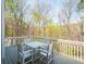 View of the back porch with white chairs, table, and railings overlooking a wooded area at 102 Stargaze Rdg, Canton, GA 30114