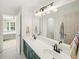 Bathroom featuring dual sinks, a large mirror, and a shower with a white curtain at 102 Stargaze Rdg, Canton, GA 30114