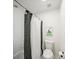 Well-lit bathroom showcasing a shower with stylish curtains and a modern toilet with art at 102 Stargaze Rdg, Canton, GA 30114