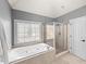 Beautifully tiled bathroom with a relaxing tub next to a window and a glass-enclosed shower at 102 Stargaze Rdg, Canton, GA 30114