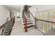 Hallway featuring hardwood stairs, detailed iron railings, and many windows for natural lighting at 102 Stargaze Rdg, Canton, GA 30114