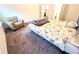 Cozy bedroom with neutral carpet, an accent chair, and a comfy bed with a fun patterned comforter at 1125 Campbell Pine Trl, Lawrenceville, GA 30045
