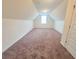 Attic bedroom with neutral walls, carpet flooring, and bright window at 1125 Campbell Pine Trl, Lawrenceville, GA 30045
