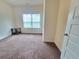 Cozy bedroom featuring neutral walls, plush carpeting, and a bright window at 1125 Campbell Pine Trl, Lawrenceville, GA 30045