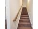 Carpeted staircase with wood railing at 1125 Campbell Pine Trl, Lawrenceville, GA 30045