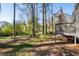 A partially shaded backyard features mature trees and access to a deck from the home at 2014 Poplar Rdg, Lawrenceville, GA 30044