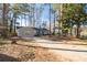 Expansive driveway leads to the lovely single-story home surrounded by lush, mature trees and new wood fence at 2014 Poplar Rdg, Lawrenceville, GA 30044
