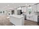 Modern kitchen with white cabinets, island, stainless steel appliances, and an open floor plan into the living room at 2014 Poplar Rdg, Lawrenceville, GA 30044