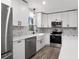 Well-equipped kitchen features white cabinets, countertops, and stainless steel appliances, creating a clean aesthetic at 2014 Poplar Rdg, Lawrenceville, GA 30044