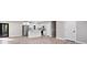A contemporary living area flows into a kitchen with stainless steel appliances and white cabinetry at 2014 Poplar Rdg, Lawrenceville, GA 30044