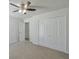 Bright bedroom features neutral carpeting, a ceiling fan, a closet, and white walls at 3285 Mitsy Forest Ne Way, Marietta, GA 30068