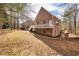 Side view of brick home featuring a deck, side yard with mature trees, and a walkway at 418 Abbey Springs Way, Mcdonough, GA 30253