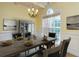 An inviting dining room features a large window, chandelier, and an expansive table set for a meal at 418 Abbey Springs Way, Mcdonough, GA 30253