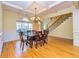 Bright dining room with hardwood floors, beautiful window, chandelier and stairway access at 418 Abbey Springs Way, Mcdonough, GA 30253