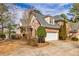 Side view of brick home with a two-car garage and landscaped surroundings, blending style and functionality at 418 Abbey Springs Way, Mcdonough, GA 30253