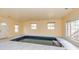 An indoor pool room featuring marble floors, multiple windows, and a door to the exterior at 418 Abbey Springs Way, Mcdonough, GA 30253