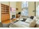 A bright living room boasts a fireplace, built-in shelves, and a large window for abundant natural light at 418 Abbey Springs Way, Mcdonough, GA 30253