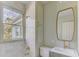 Stylish bathroom with white tile, gold fixtures, and natural light from a window at 232 Westminster Ne Dr, Atlanta, GA 30309