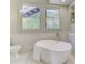 Elegant bathroom showcasing a soaking tub, framed window, and vanity with countertop space for a spa-like retreat at 232 Westminster Ne Dr, Atlanta, GA 30309