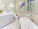 Elegant bathroom showcasing a soaking tub, framed window, and vanity with countertop space for a spa-like retreat at 232 Westminster Ne Dr, Atlanta, GA 30309